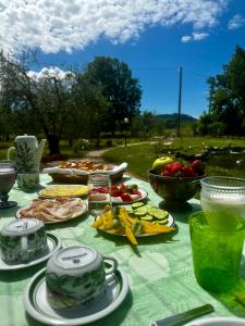 een tafel met borden voedsel op een groene tafelkleed bij La Bertinora in Villa Verucchio