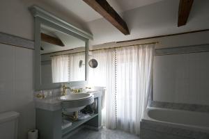uma casa de banho com um lavatório, uma banheira e um espelho. em Antonius Hotel em Tartu