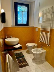 baño con aseo y lavabo y ventana en La Bertinora, en Villa Verucchio