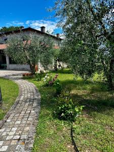un camino de ladrillo delante de un patio con una casa en La Bertinora, en Villa Verucchio