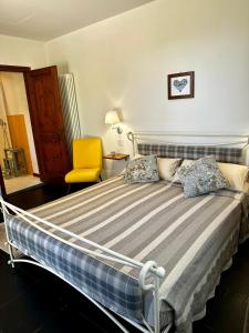 een slaapkamer met een bed en een gele stoel bij La Bertinora in Villa Verucchio