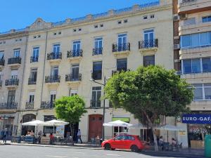 a red car parked in front of a building at 120 sqm Loft-style Apartment Beach Royal Marina in Valencia