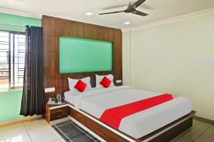 a bedroom with a large bed with a green screen at OYO Flagship Hi5 Days Inn Premium in Bhubaneshwar