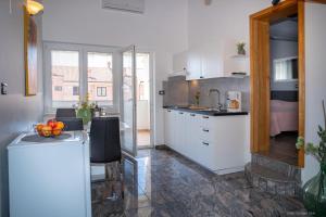cocina con armarios blancos y encimera en Guesthouse Mila, en Rovinj