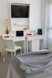 ポルト・デ・ラ・セルバにあるHotel Spa Cap de Creusのベッドルーム(白いデスク、テレビ付)