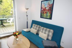 瓦爾內明德的住宿－H&P Residenz am Kurpark Warnemünde，客厅配有一张蓝色的沙发,配有一张桌子
