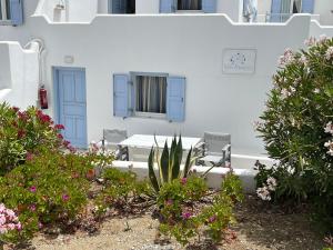 biały budynek z niebieskimi drzwiami i kwiatami w obiekcie Villa Margarita w mieście Mykonos