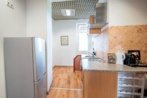 a kitchen with a stainless steel refrigerator and wooden floors at Stadtoase nähe Uni Design Wohnung mit 2 Schlafzimmern & Sauna in Koblenz