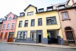 a yellow house on the side of a street at Stadtoase nähe Uni Design Wohnung mit 2 Schlafzimmern & Sauna in Koblenz