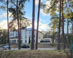 a large white building with trees in front of it at Velvet loft apartment city centre in Narva-Jõesuu