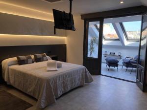 sypialnia z łóżkiem i przesuwanymi szklanymi drzwiami w obiekcie La Aduana - The Lodging Experience w mieście Astorga