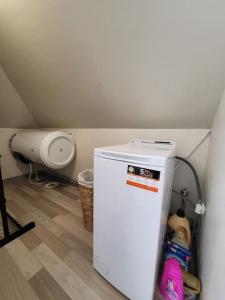 a small white refrigerator in a corner of a room at Velvet loft apartment city centre in Narva-Jõesuu