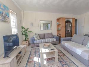 ein Wohnzimmer mit einem Sofa und einem Tisch in der Unterkunft O'Briens in Gordonʼs Bay