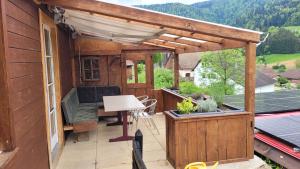 un patio al aire libre con pérgola de madera en aschis Lodge 2 en Soubey