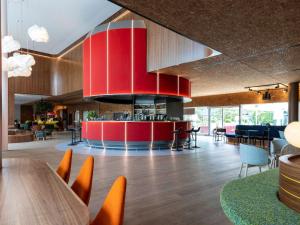 a restaurant with a red island in the middle of a room at Novotel Zurich City West in Zürich