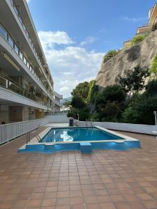 une piscine au milieu d'un immeuble dans l'établissement Tossa de Mar Veran, parking Wifi, 100m de la playa, à Tossa de Mar