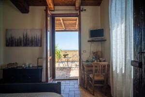 Schlafzimmer mit einer Tür, die auf eine Terrasse mit einem Tisch führt in der Unterkunft Il Castellaro in Borghi