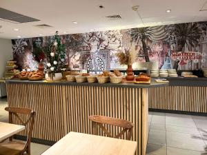 um restaurante com um balcão com comida em ibis Styles Nimes Gare Centre em Nîmes