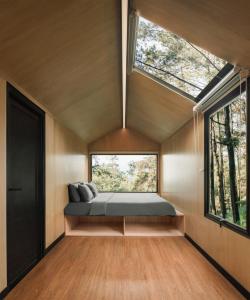 een slaapkamer met een bed in een kamer met een raam bij Bobocabin Pacet, Mojokerto in Claket