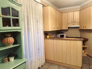 a kitchen with wooden cabinets and a counter top at Apartamento LA PLAZA in Bogarra