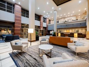 an open lobby with chairs and tables and a bar at Embassy Suites Chicago - Downtown River North in Chicago +47 photos