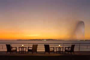 a table with candles and chairs on the beach at sunset at Park Hyatt Jeddah - Marina, Club and Spa in Jeddah