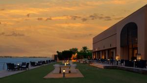 a building with tables and chairs next to a body of water at Park Hyatt Jeddah - Marina, Club and Spa in Jeddah