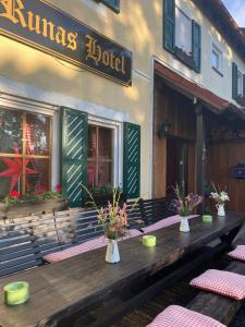 stół na zewnątrz budynku z kwiatami w obiekcie Runa´s Hotel w mieście Hallbergmoos