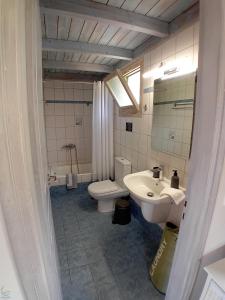 y baño con lavabo, aseo y espejo. en Muses Villas, en Finikounta