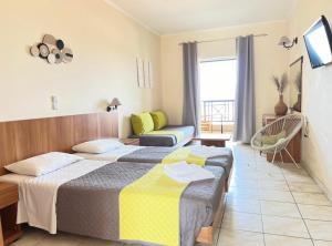 a hotel room with two beds and a chair at Ariadne Apartments in Tsilivi