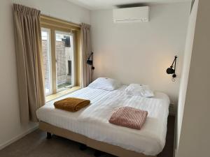 een slaapkamer met een bed met 2 kussens erop bij Long John's Pub & Hotel in Amersfoort