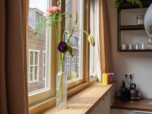 un jarrón con flores sentado en el alféizar de la ventana en Long John's Pub & Hotel en Amersfoort