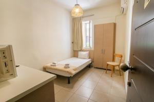 1 dormitorio pequeño con 1 cama y 1 silla en City Plus Rhodes Hotel, en Rodas