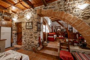 cocina y sala de estar con pared de piedra en Agapi's Charming Retreat - Rustic Escape By Chania en Maláxa