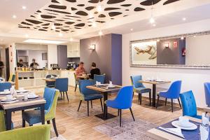 a dining room with tables and blue chairs at Boutique Hostemplo Sagrada Familia in Barcelona