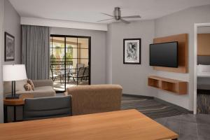 uma sala de estar com um sofá e uma televisão em Embassy Suites La Quinta Hotel & Spa em La Quinta