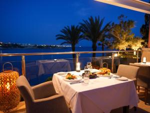 einen Tisch mit Tellern aus Essen auf einem Balkon in der Nacht in der Unterkunft Thalassa Boutique Hotel & Spa in Coral Bay
