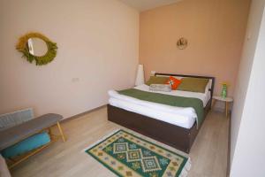 Dormitorio con cama con espejo y alfombra en Chamich Guesthouse en Debed