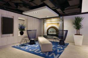 Habitación con 2 sillas y alfombra azul en TRYP by Wyndham Isla Verde en San Juan