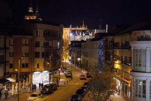 a city street at night with cars parked at La Aduana The Lodging Experience in Astorga
