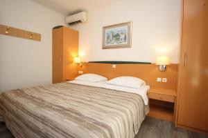 a bedroom with a large bed with two pillows at Villas Corinthia in Baška