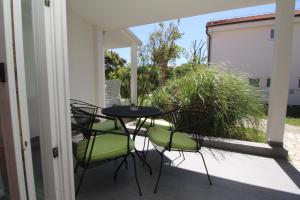 a patio with a table and chairs on a balcony at Villas Corinthia in Baška