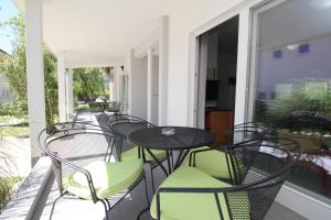 a patio with tables and chairs on a balcony at Villas Corinthia in Baška