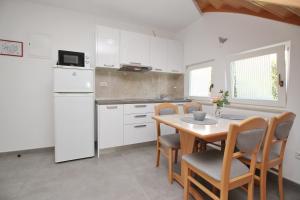 a kitchen with a table and chairs and a refrigerator at Villas Corinthia in Baška