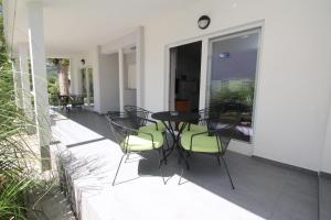 a patio with a table and chairs on a balcony at Villas Corinthia in Baška