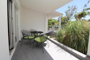 a patio with chairs and a table on a balcony at Villas Corinthia in Baška