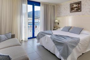 ポルト・デ・ラ・セルバにあるHotel Spa Cap de Creusのベッドとバルコニー付きのホテルルーム