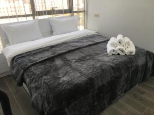 Apartment in centre of Yerevan في يريفان: غرفة نوم مع سرير كبير مع اثنين من حيوانات المنشفة عليها