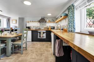 a kitchen with a wooden counter top and a table at Cascade Cottage in Exford