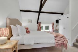 a bedroom with a white bed and a table at Cascade Cottage in Exford